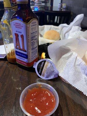 Empty steak sauce bottle, whipped spread, runny ketchup and over spiced fries covered in who knows what