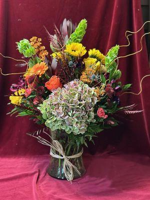 We create customer vase arrangements with fresh flowers. Call for pricing.