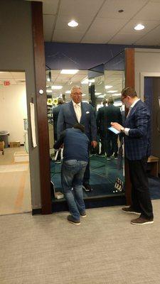 Cherif consulting with tailor for the perfect fit