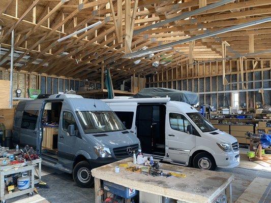 Custom build 4x4 sprinter next to white Airstream sprinter.