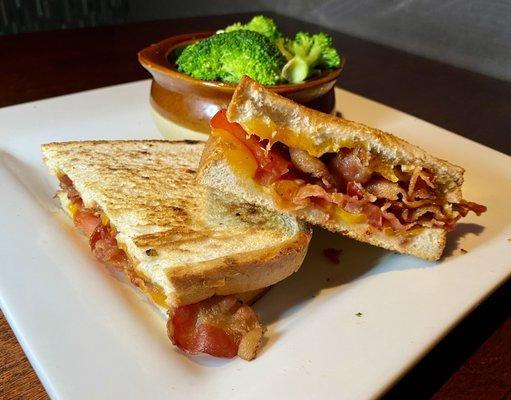 Special grilled cheese with bacon and a side of broccoli.