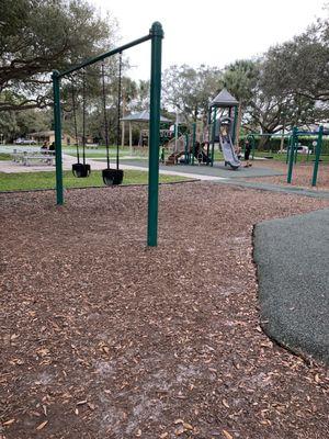 Swings for little kids and farther back playground for bigger kids.