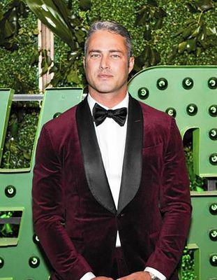 Taylor Kinney wears a merlot velvet dinner jacket during Chicago Green Tie Ball.