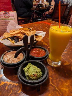 Complimentary chips and salsa and frozen mango margarita mocktail