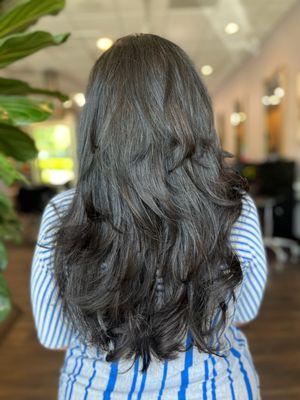 Long espresso brown hair with textured layers.