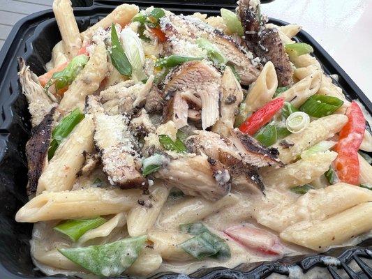 Jerk flavored chicken & pasta with creamy sauce nicely seasoned then it also has peppers and greens onions. Get some!