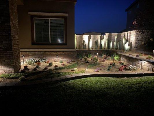 Drought tolerant planting & design. Paired with Country Manor Brown stone raised planter & Alliance outdoor lighting