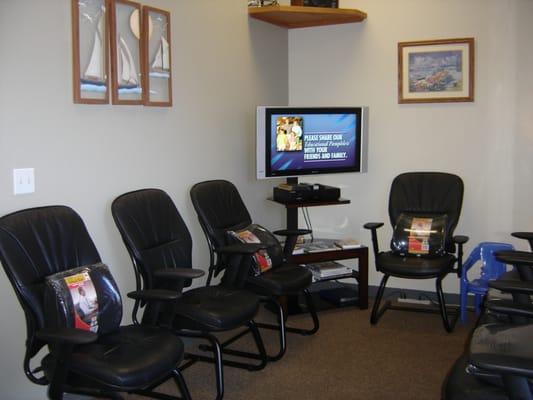 Reception area with ocean inspired artwork and an educational patient video and reading materials