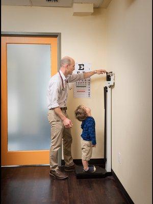 Dr. Ryan Campbell measuring height of young patient in West Seattle