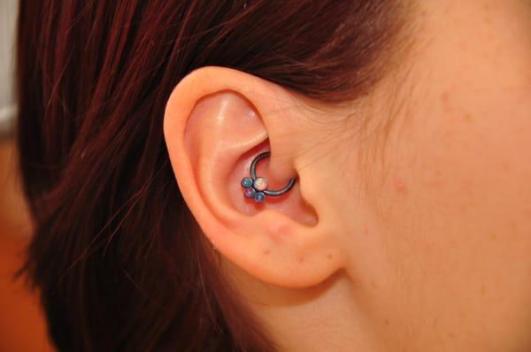 16g daith piercing with titanium anodized blue CBR,  teal opals and a white opal center