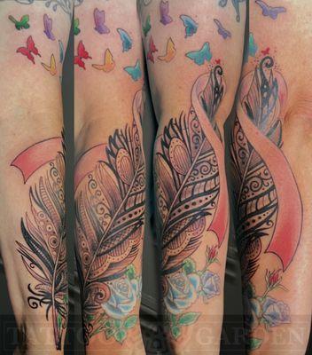 Decorative feather with cancer ribbon wrapped around forearm and dissolving into butterflies.