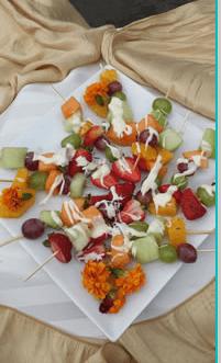 Fruit skewers drizzled with white chocolate.