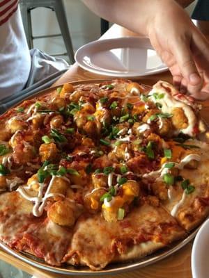 Order a cheese pizza and a order of Tot-Chos, then ask them to put the Tot-Chos on the pizza. Its heavenly!