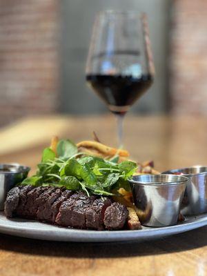 Savor our steak frites: tender, juicy steak cooked to perfection, paired with crispy, hand cut golden fries and a flavorful herb butter.