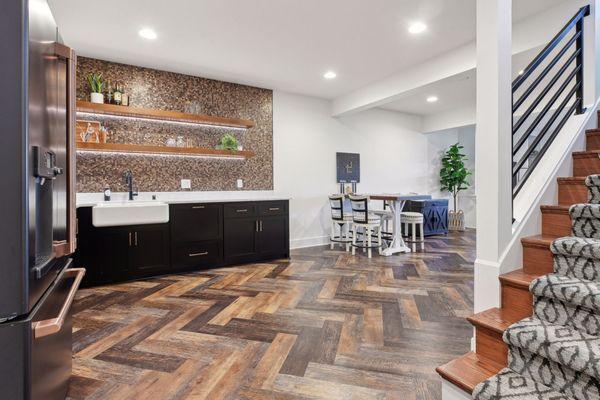 Turn your lower level into your dream living area with a custom bar and flooring like this! Just beautiful!