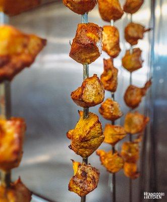 Fresh kebobs being pulled out of tandoor