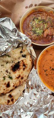 Butter chicken and garlic naan and tilapia curry pictured on top.