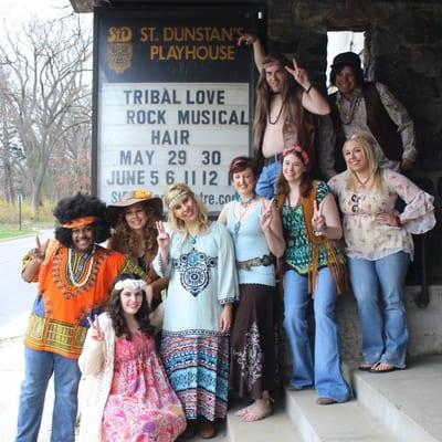 Some of the Hair cast in front of the sign on Lone Pine on the Cranbrook campus.