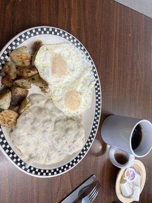 One biscuit with sausage gravy and a side of two eggs.