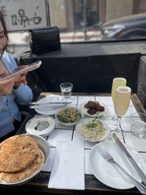 The 'choose 4' small plates: labneh, baba ganoush, falafel and tahini, tabouli salad Orange mimosa and grapefruit mimosa glass