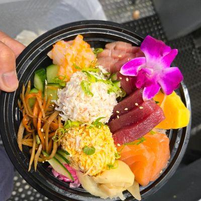 Chirashi Bowl featuring Tuna, Salmon, Hamachi, Ika with Masago, Spicy Crab, Crab Mix and seasoned veggies.