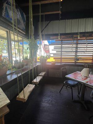 Swings to sit on at the front of the restaurant