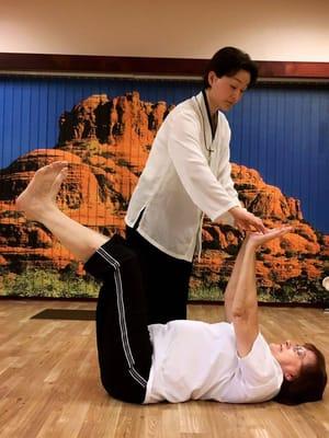 Master Suhaeng assists a student with Sleeping Tiger pose.