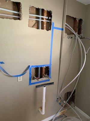 Measured out and cut drywall to connect to water source.