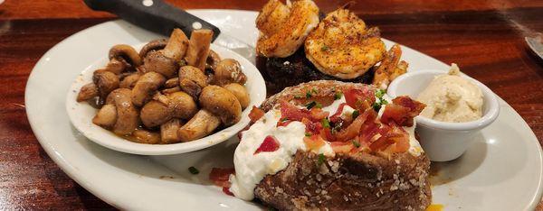 Steak covered with shrimp, sautéed mushrooms and loaded baked potato.