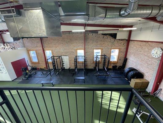 First floor squat racks, windows looking out to the ample parking