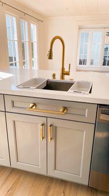 Kitchen island with brushed gold hardware and modern single basin sink