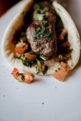 Our Lamb Kebab Pita Wrap paired with grilled vegetables, Tzatziki and a Fatoush medley wrapped in a warm pita.