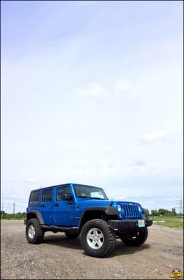 Blue 2016 Jeep Wrangler with a 3" lift and 35" tires.