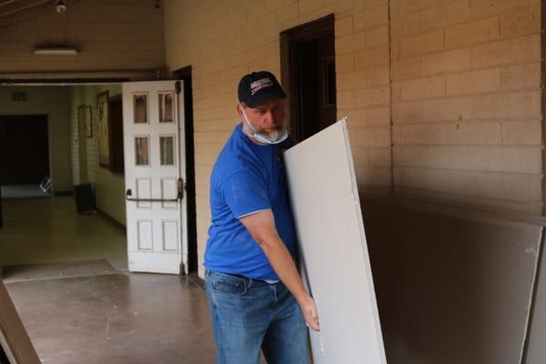 Pastor/Elder Ricky Aulds helps move some sheetrock into the children's rooms that were being renovated.