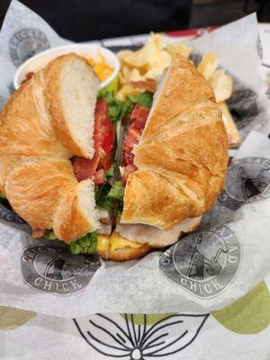 BLT turkey sandwich on croissant bread with cheese potato soup with side regular potato chips.