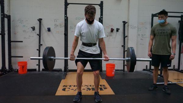 Eric watching a member attempt a Deadlift PR