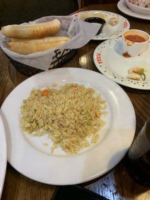 Side of rice with the plate and free breadsticks.