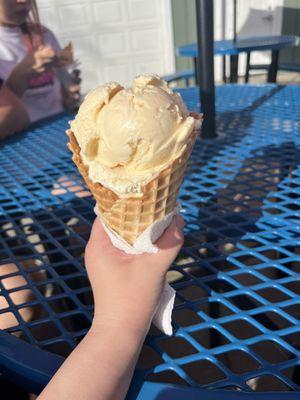 1 scoop of lemon and 1 scoop of toasted almond in a waffle cone