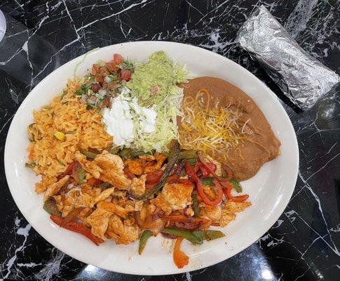 Chicken fajitas with corn shells, rice, beans, and "salad".