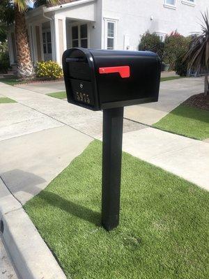 New mailbox and aluminum post cemented into ground.