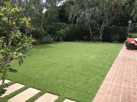 Synthetic turf looks great around steps, trees and pathways.