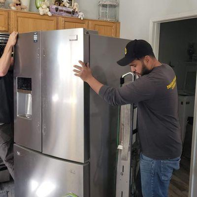 Tucson Appliance team removing the old fridge