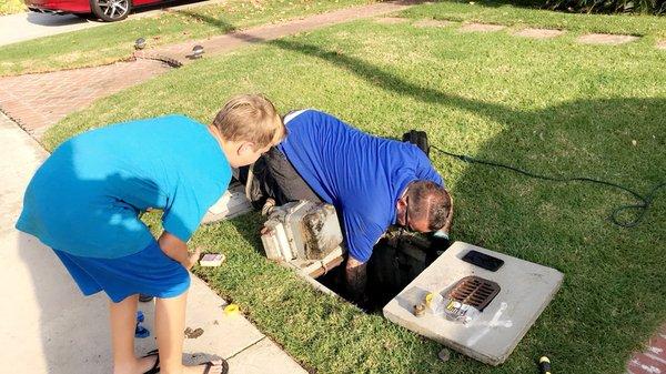 Father and son repairing a gas line.