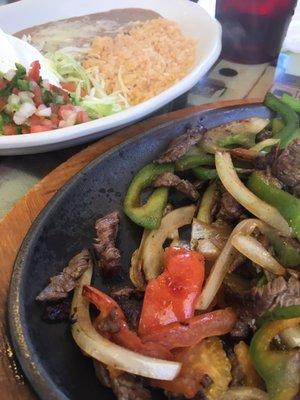 Steak fajita with rice, beans, and salad.