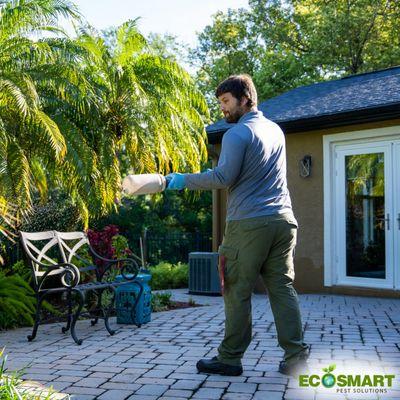 Pest Control Technician performing exterior treatment.