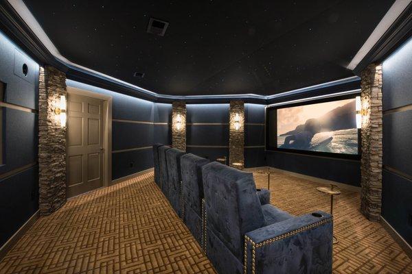 Floor to ceiling custom theater design with walls and ceiling wrapped in acoustic treatment, lighting, and Dolby Atmos Surround Sound