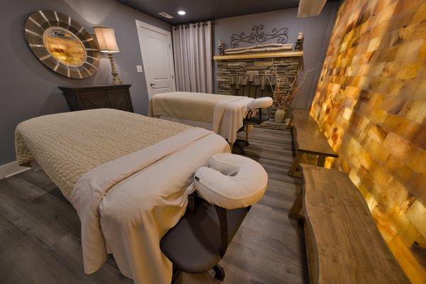 Downstairs couple's massage room with full himalayan salt walls and fireplace decoration.