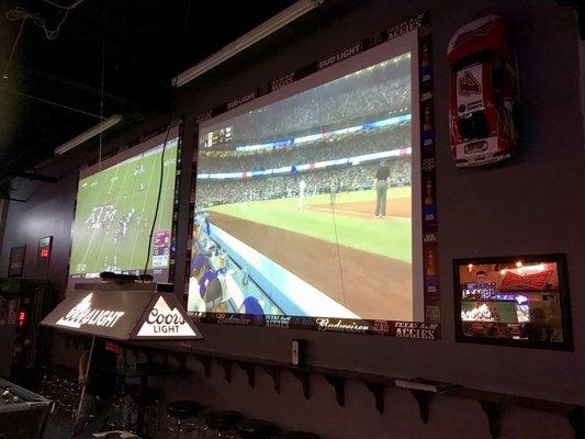 2 Big giant screen tv's on top of pool tables...