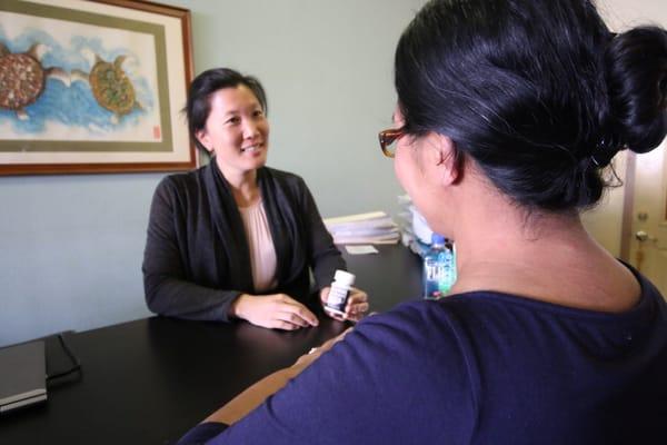 Explaining how to take herbal tea pills. Photo by N. Ito.