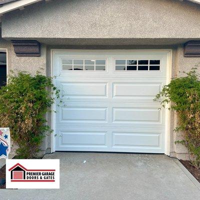 New single-car garage door installation with elegant windows installed, enhancing natural light and aesthetic appeal effortlessly